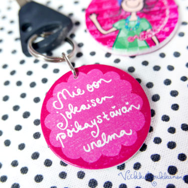 Pyöreä puinen Suomessa valmistettu Virkkukoukkusen suunnittelema pinkki avaimenperä "Mie oon jokaisen poikaystävän unelma" - tekstillä.