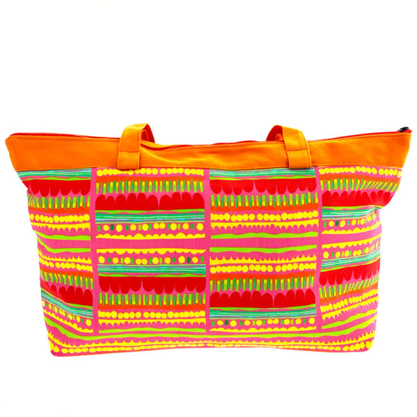 Virkkukoukkusen suunnittelema Suomessa tehty Reilu-laukku vetoketjullisella sisätaskulla. Kuosina iloisen värikäs Optimisti oransseilla kahvoilla.