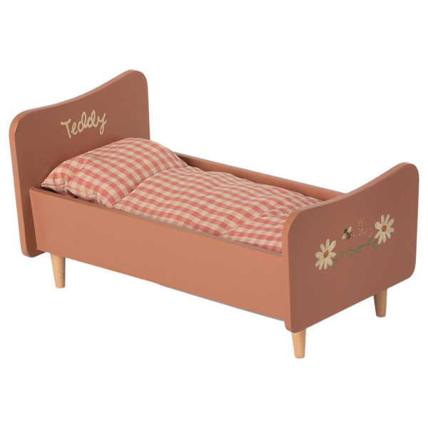 Mailegin roosa puinen sänky ruudullisilla petivaatteilla.