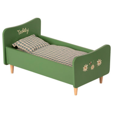 Mailegin vihreä puinen sänky ruudullisilla petivaatteilla.