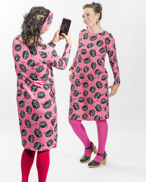 Kotimainen Virkkukoukkusen tulppaanin mallinen pitkähihainen collegekankainen Simpsakka-mekko pyöreällä pääntiellä ja pinkkipohjaisella Mustat kissat -kuosilla.