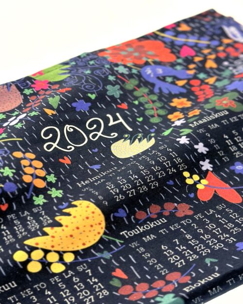Virkkukoukkusen ihana kalenteripyyhe vuodelle 2024 "Joku päivä on nyt" -tekstillä. Kaunis mustapohjainen kukkakuosi erivärisillä kukilla ja sinisillä linnuilla. Puolipellavainen keittiöpyyhe on printattu Suomessa.